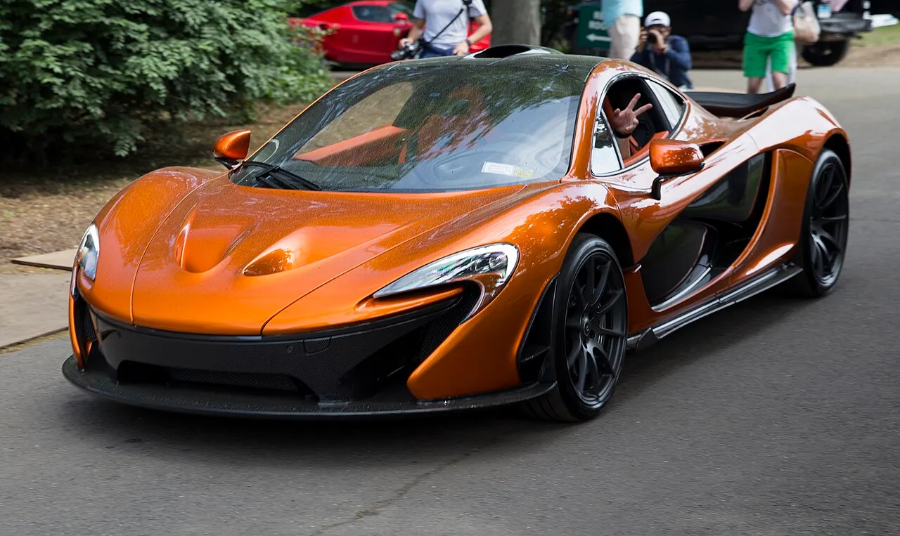 2014 McLaren P1 (Volcano Orange, front left), leaving Greenwich 2018 — model reference, not inventory photo